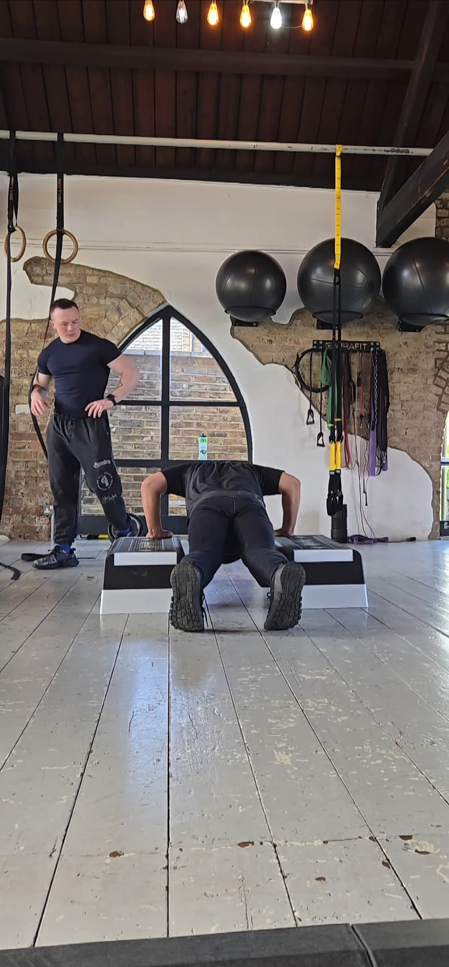 Harry Phillips coaching anti-extension core work at West 4 Gym, Chiswick. The same patterning that protects a sciatic nerve under load